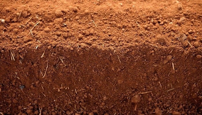 A close up of several layers of red clay soil.