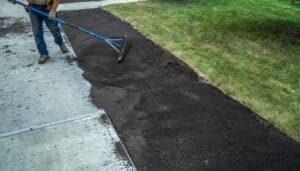 Landscaper Applying Top Soil On Yard