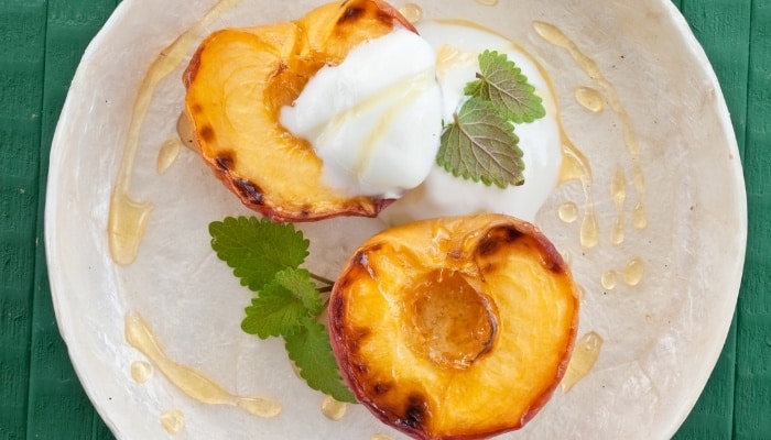 Grilled peach halves topped with yogurt, mint, and honey.