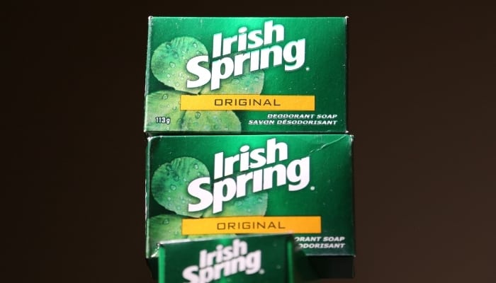 Three boxes of Irish Spring soap stacked against a brown background.