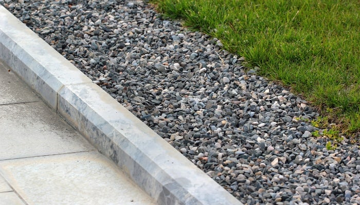 A gravel border separating a walkway from a lawn.