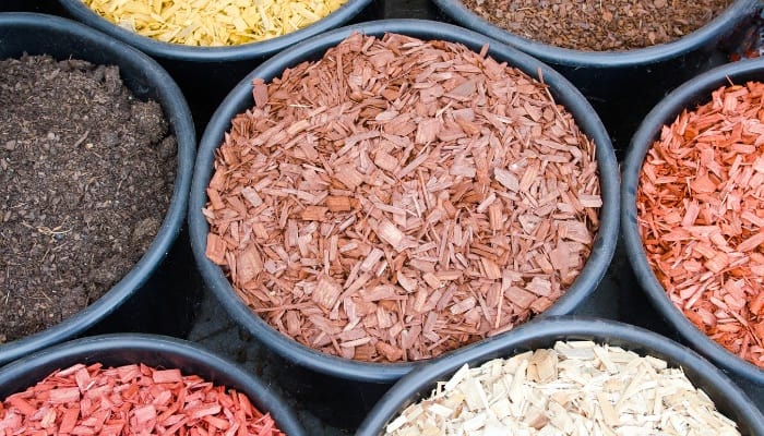 A variety of different-colored mulches in round bins.